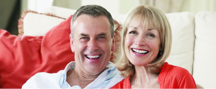 Middle-aged man and woman sitting together smiling