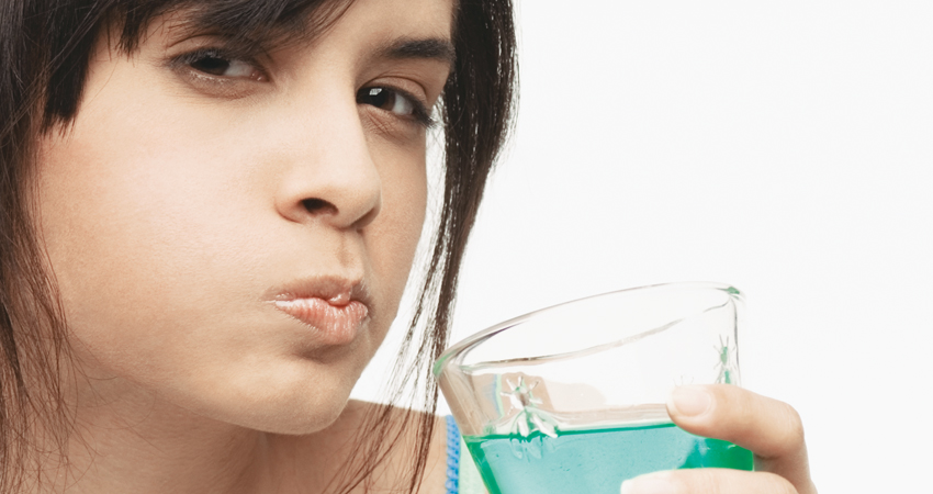 caucasian woman swishing mouthwash